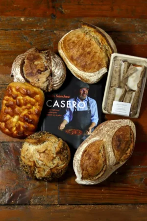 Pack Casero – Regalo Pack Casero Familiar de Cenador de Amós, elaborado artesanalmente en nuestro obrador, que incluye el Libro Casero 2025 y una selección de nuestros mejores panes tradicionales con alma, diseñado para compartir momentos únicos en familia.